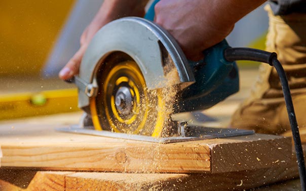 A handy person cutting wood with a circular saw